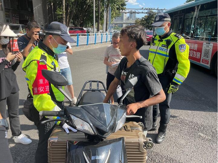 民警在街頭勸導(dǎo)摩托車駕駛員。實(shí)習(xí)生越倚航攝