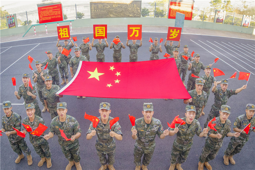 武警官兵與國旗同框，祝福祖國。李東攝