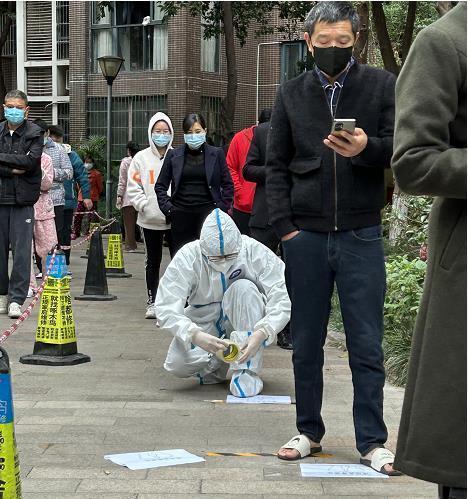 裴海民（著防護服者）在檢測點進行志愿服務。